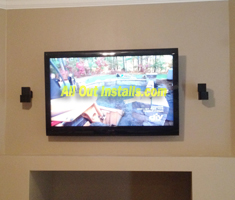 AllOutInstalls.com Flat panel TV mounted on wall above fire place with 2 speaker installation
